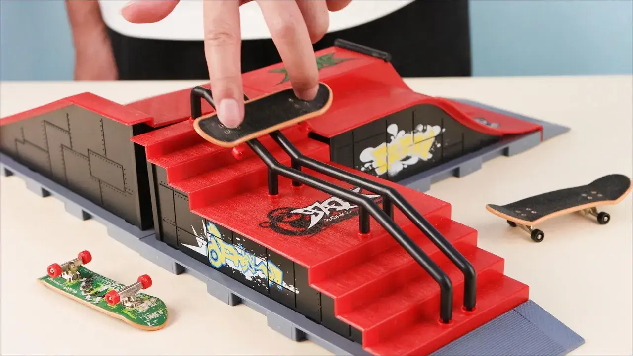 Palec manewruje małą deskorolką po miniaturowym skateparku tech deck, gotowym na triki.